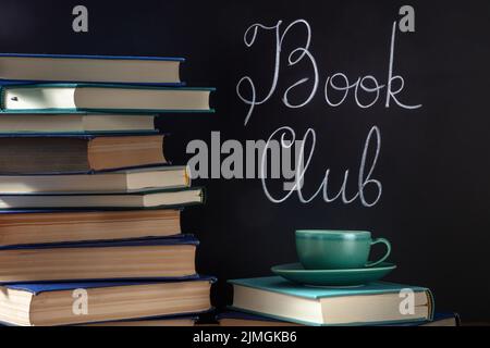 Club-Konzept Buchen. Ein Stapel Hardcover-Bücher mit einer Tasse Kaffee Stockfoto