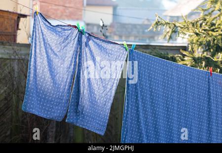 Die Bettwäsche hing draußen auf dem Wäscheständer Stockfoto