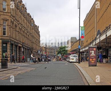 Menschen, die an Geschäften in der Marktstraße in halifax West yorkshire vorbeilaufen Stockfoto