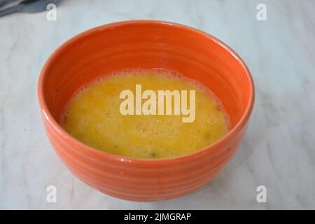 Gesundes Essen, Rühreier in einen orangefarbenen Tonteller gegossen. Stockfoto