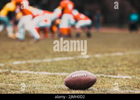 American Football auf dem Feld - Unschärfe-Spieler im Hintergrund Stockfoto