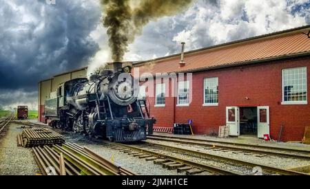 Restaurierte Dampfmaschine, die für den Service bereit ist, Rauch und Dampf bläst Stockfoto