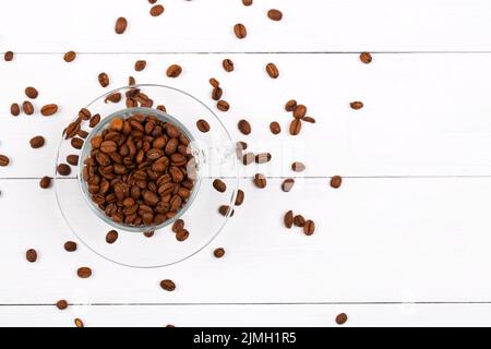 Kaffeebohnen in der Tasse auf einem hölzernen Hintergrund Stockfoto