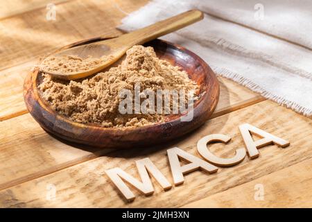 Maca-Pulver, in Holzschale auf dem Tisch, Nährstoff aus Peru. Stockfoto