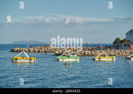 Badebucht mit Tretbooten an der Küste der Adria in der Nähe der Stadt Krk in Kroatien Stockfoto