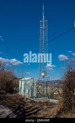 Mobilfunkantenne Turm in ländlicher Umgebung gegen blauen Himmel. Sendeturm in der Natur. Stockfoto