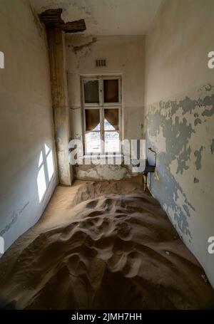 Verlassene Diamantenmine, die den Abbruch des Bauens zeigt und von der Natur zurückgewonnen wurde, Kolmanskop, Luderitz, Namibia Stockfoto