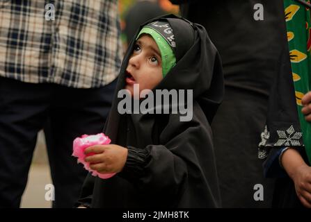 Srinagar, Indien. 06. August 2022. Ein schiitisches muslimisches Mädchen schaut zu, als sie an einer Prozession am 7.. Tag von Muharram teilnimmt. Muharram ist der erste Monat des Islam. Es ist einer der heiligsten Monate im islamischen Kalender. Schiitische Muslime gedenken Muharram als einen Monat der Trauer zum Gedenken an das Martyrium des Enkels des islamischen Propheten Muhammad Imam Hussain, der 680 n. Chr. in der Schlacht von Karbala an Aschura (10.. Tag von Muharram) getötet wurde (Foto: Idrees Abbas/SOPA Images/Sipa USA) Quelle: SIPA USA/Alamy Live News Stockfoto