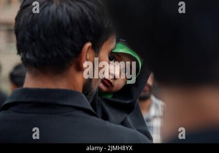 Srinagar, Indien. 06. August 2022. Ein schiitisches muslimisches Mädchen schaut zu, als sie an einer Prozession am 7.. Tag von Muharram teilnimmt. Muharram ist der erste Monat des Islam. Es ist einer der heiligsten Monate im islamischen Kalender. Schiitische Muslime gedenken Muharram als einen Monat der Trauer zum Gedenken an das Martyrium des Enkels des islamischen Propheten Muhammad Imam Hussain, der 680 n. Chr. in der Schlacht von Karbala an Aschura (10.. Tag von Muharram) getötet wurde (Foto: Idrees Abbas/SOPA Images/Sipa USA) Quelle: SIPA USA/Alamy Live News Stockfoto