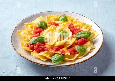 Ravioli mit Tomatensauce und frischem Basilikum auf einem Teller. Gesunde Mahlzeit Stockfoto