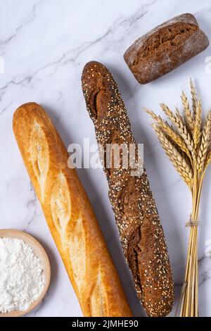 Bäckerei - verschiedene Arten von Brotwaren. Brötchen, Baguette, Croissant und Mehl Stockfoto