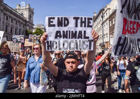 London, England, Großbritannien. 6. August 2022. Ein Protestler in Whitehall hält ein Plakat mit dem Aufsteller „End the animal Holocaust“. Tausende von Menschen marschierten durch das Zentrum Londons, um Tierrechte und Veganismus zu unterstützen, und forderten ein Ende des Artenismus und aller Formen der Tierausbeutung. (Bild: © Vuk Valcic/ZUMA Press Wire) Stockfoto