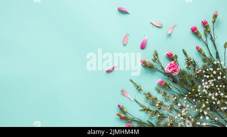 Rosa Blumen mit Pflanzenzweigen Tisch Stockfoto