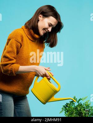Frau mit mittlerer Schussaufnahme und Gießkannne Stockfoto