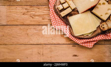 Verschiedene Arten Käse Holzuntersetzer mit Tischtuch Bank Stockfoto