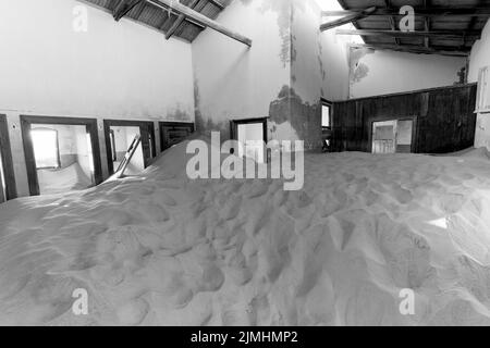 Verlassene Diamantenmine, die den Abbruch des Bauens zeigt und von der Natur zurückgewonnen wurde, Kolmanskop, Luderitz, Namibia Stockfoto