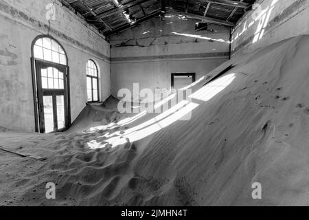 Verlassene Diamantenmine, die den Abbruch des Bauens zeigt und von der Natur zurückgewonnen wurde, Kolmanskop, Luderitz, Namibia Stockfoto