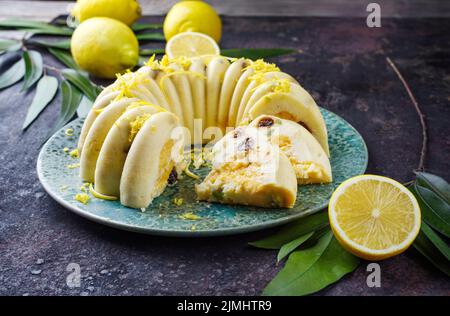 Traditioneller italienischer Budino di Ricotta-Käsepudding mit Rosinen und Zitronencreme, der als Nahaufnahme auf einem Design-Teller serviert wird Stockfoto