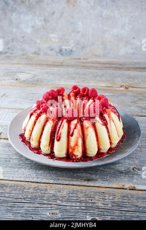 Traditioneller italienischer Budino di Ricotta Käsekuchen-Pudding mit Schokolade crÃ¨me und Himbeerbeer-Belag, der als Nahaufnahme auf einer des serviert wird Stockfoto