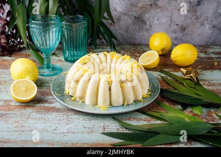 Traditioneller italienischer Budino di Ricotta-Käsepudding mit Rosinen und Zitronencreme, der als Nahaufnahme auf einem Design-Teller serviert wird Stockfoto