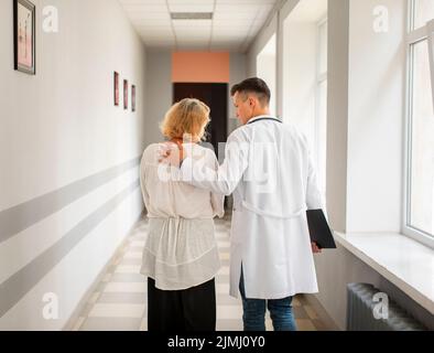 Rückansicht Arzt ältere Frau beim Gehen Stockfoto