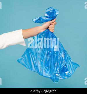 Frau mit blauem Plastikmüllbeutel Stockfoto