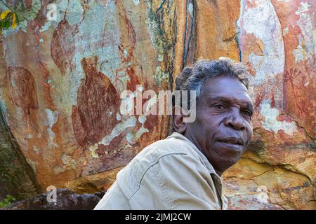 Porträt von Neville Namarnyilk, einem Aborigine-Künstler aus dem Arnhem Land, vor Felskunst, East Alligator River, Northern Territory, Australien Stockfoto