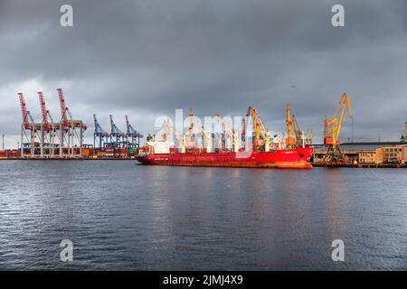 Odessa, Ukraine. 10. September 2018. Handelsschiff während der Verladung am Hafen von Odessa vor dem Hintergrund der Ladekrane während des Sonnenuntergangs. Zum ersten Mal seit Beginn des russischen Angriffskrieges gegen die Ukraine hat ein Getreideschiff den Hafen von Odessa verlassen. Dadurch sollen Millionen Tonnen Getreide wieder für den Weltmarkt verfügbar gemacht werden. Vor dem russischen Angriffskrieg war die Ukraine einer der wichtigsten Getreideexporteure der Welt. Für sie geht es um Milliarden an Einnahmen aus dem Verkauf von Weizen und Mais, unter anderem von Rohstoffen. (Kreditbild Stockfoto