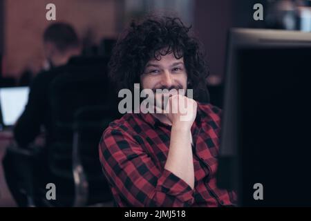 Lächelnder Geschäftsmann mit Headset, der virtuelle Teambesprechung in einer Gruppe führt und mit verschiedenen Mitarbeitern im Kundensupport chattet. Vid Stockfoto