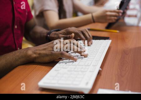 Anonymer schwarzer Mann beim Tippen Stockfoto