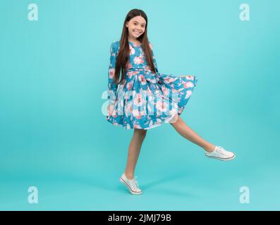 Elegante Teenager Kind Mädchen in Mode Sommerkleid. Mädchen in Baumwollkleid auf blauem Hintergrund isoliert gekleidet. Fröhlicher Teenager, positiv und lächelnd Stockfoto