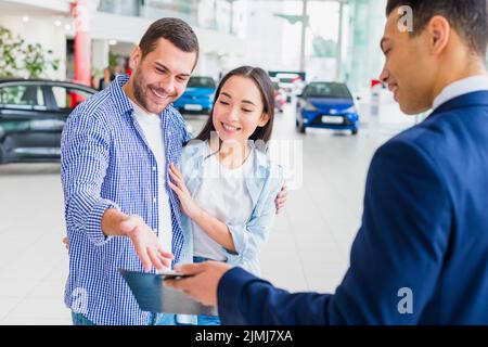 Autohändler im Gespräch mit Kunden Stockfoto