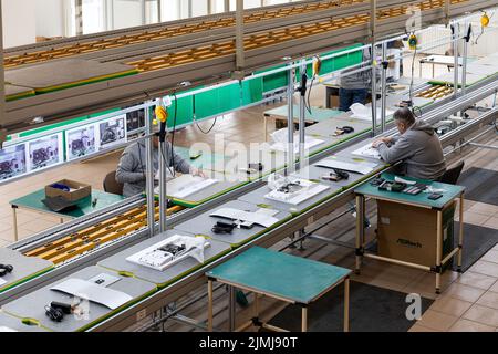 Minsk, Weißrussland - 15. Dezember 2021: Foto einer Anlage zur Montage von Monoblocks für Computer. Arbeiter arbeiten an einem Förderband. Mo Stockfoto