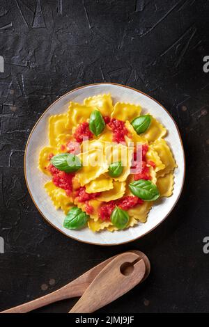 Ravioli mit Tomatensauce und frischen Basilikumblättern, von oben geschossen Stockfoto
