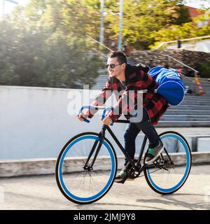 Junger Mann mit Tasche Fahrrad fahren Stockfoto