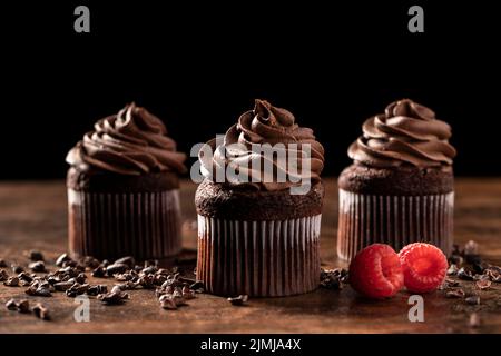 Nahaufnahme köstlicher Cupcakes aus Schokolade mit Himbeere Stockfoto