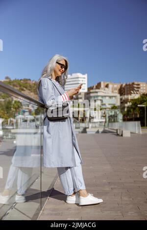 Foto von charmanten Frau mit Smartphone in der Stadt Stockfoto