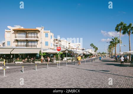 Paphos, Zypern - 29. Okt 2014: Poseidonos Ave, Paphos, Zypern mit Touristen und Einheimischen in der Nähe der Hafenrestaurants, Souvenirladen hohe Palmen Stockfoto