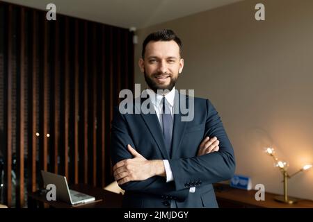 Porträt eines erfolgreichen Geschäftsmannes vor dem Hintergrund eines starken teuren Büros Stockfoto