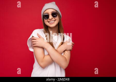 Foto von jungen positiven glücklich lächelnd schöne Frau mit aufrichtigen Emotionen tragen stilvolle Kleidung isoliert über Hintergrund Witz Stockfoto