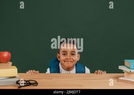 Niedlicher Junge mit Rucksack Verstecktisch Stockfoto