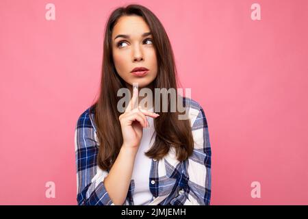 Fotoporträt der jungen schönen denkenden und träumenden Brünette Frau in trendigen blauen und weißen Hemd. Weibliche Person, die Isol posiert Stockfoto