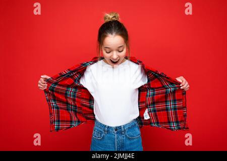 Porträt der jungen attraktiven erstaunt positiv glücklich schockiert Hipster blonde Frau in stilvollen roten Hemd und lässigen weißen T-Shirt. S Stockfoto