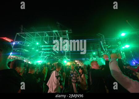 Kastellaun, Deutschland. 07. August 2022. Raver tanzen beim Techno-Festival „Nature One“. Das Festival auf dem ehemaligen amerikanischen Kreuzraketen-Stützpunkt in Hunsrück konnte wegen der Pandemie zwei Jahre lang nicht stattfinden. In diesem Jahr erwarten die Veranstalter rund 60000 Besucher. Quelle: Thomas Frey/dpa/Alamy Live News Stockfoto