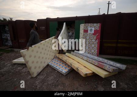 Peshawar, Khyber Pakhtunkhwa, Pakistan. 5. August 2022. Die Arbeiter laden Hilfsmaterial in einen Zug, damit die Flutopfer von der Regierung Khyber Pakhtunkhwa in Peshawar in die von Überschwemmungen betroffenen Gebiete der Provinz Balochistan geschickt werden können. Laut der National Disaster Management Authority (NDMA) sind mindestens 357 Menschen gestorben, darunter 140 Kinder, und weitere 408 wurden seit Beginn der Monsunsaison aufgrund von Regenfällen und Sturzfluten verletzt. Pakistan gehört zu den 10 Ländern, die am stärksten vom Klimawandel betroffen sind. (Bild: © Hussain Ali/Pacific Press via ZUMA Press Wire) Stockfoto