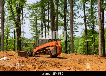 Ein Baugewerblicher Grader wird bei der Nivellierung des Grundstücks verwendet, um es für ein neues Gebäude in der Bauindustrie zu verwenden Stockfoto