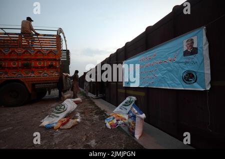 Peshawar, Khyber Pakhtunkhwa, Pakistan. 5. August 2022. Die Arbeiter laden Hilfsmaterial in einen Zug, damit die Flutopfer von der Regierung Khyber Pakhtunkhwa in Peshawar in die von Überschwemmungen betroffenen Gebiete der Provinz Balochistan geschickt werden können. Laut der National Disaster Management Authority (NDMA) sind mindestens 357 Menschen gestorben, darunter 140 Kinder, und weitere 408 wurden seit Beginn der Monsunsaison aufgrund von Regenfällen und Sturzfluten verletzt. Pakistan gehört zu den 10 Ländern, die am stärksten vom Klimawandel betroffen sind. (Bild: © Hussain Ali/Pacific Press via ZUMA Press Wire) Stockfoto