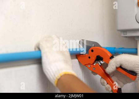 Klempner installiert schwimmende Pipeline an der Wand im alten Bad. Stockfoto