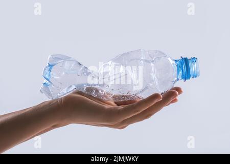 Weibliche Hand mit einer gebrauchten Plastikflasche Stockfoto