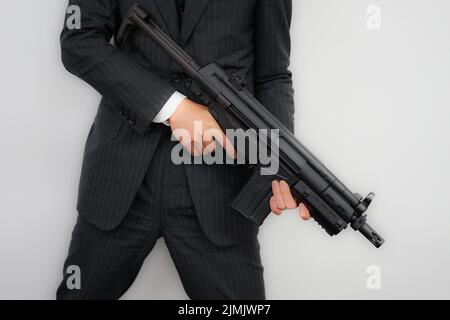 Geschäftsmann mit einem Maschinengewehr zu kämpfen Stockfoto